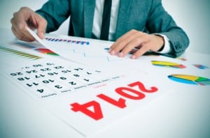 man in suit with charts and a 2014 calendar
