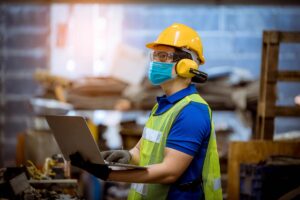 Worker under inspection and checking production process on factory station by wearing safety mask to protect for pollution and virus in factory.