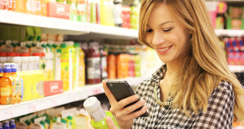 grocery lady scanning phone in aisle feature